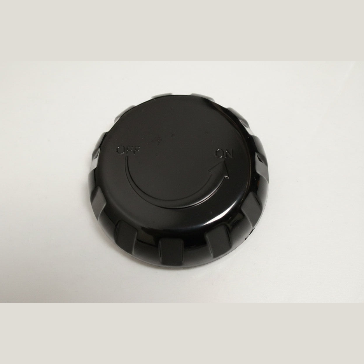 Round black air control cover with scalloped grip edge and embossed OFF ON arrow